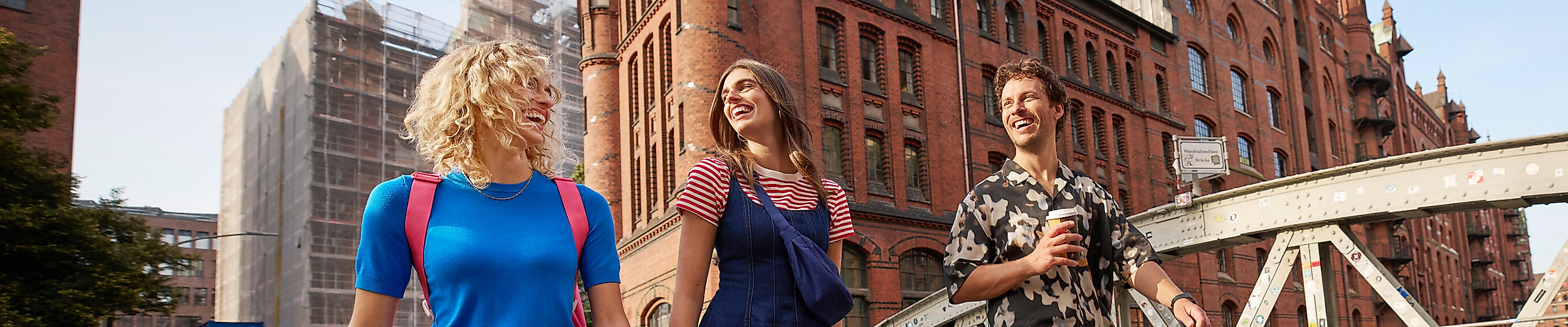 Drei junge Erwachsene spazieren durch die Speicherstadt in Hamburg.
