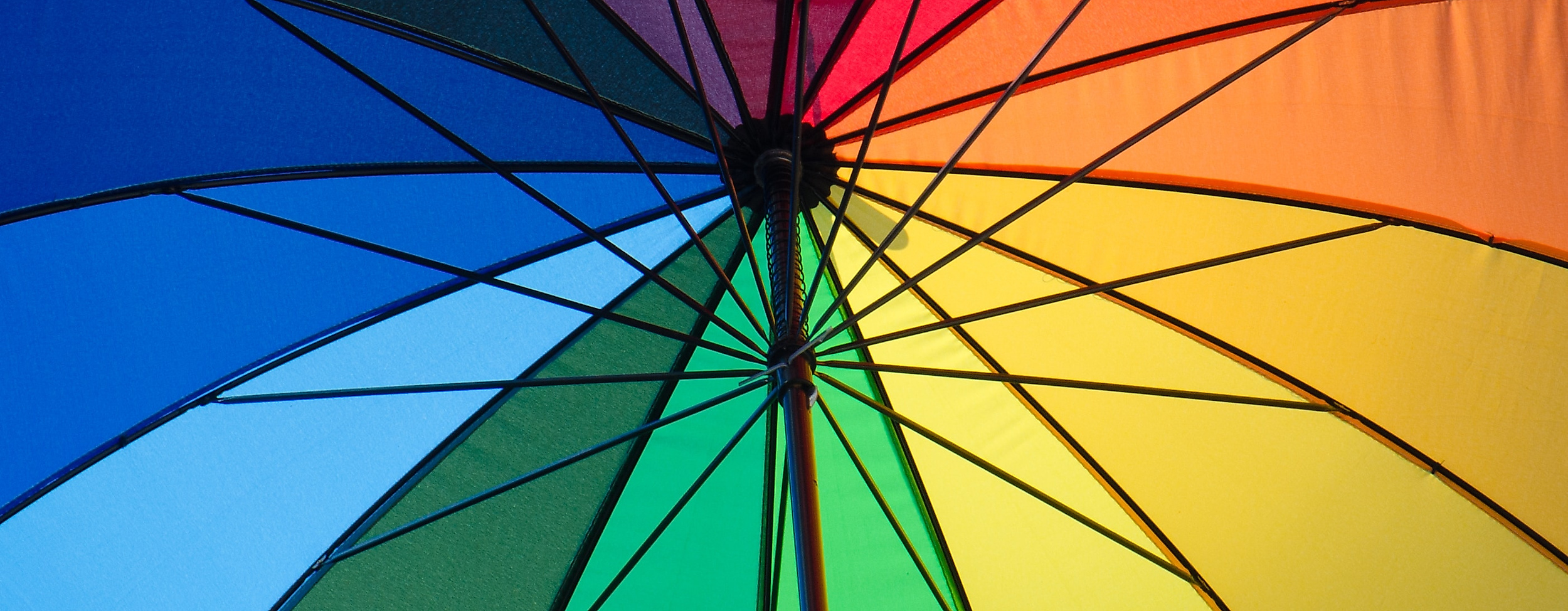 Aufgespannter Regenschirm in Regenbogenfarben als Symbol für Vielfalt und jedes Wetter in Hamburg