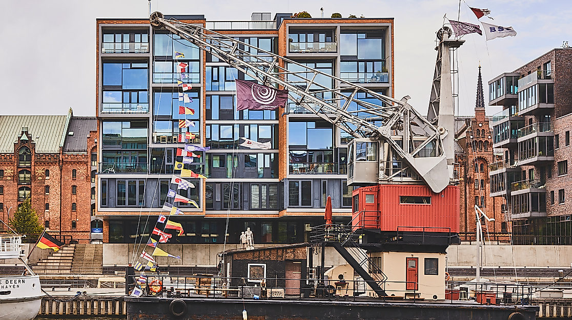 Historischer Hafenkran im Sandtorhafen vor moderner Glasfassade in der HafenCity Hamburg