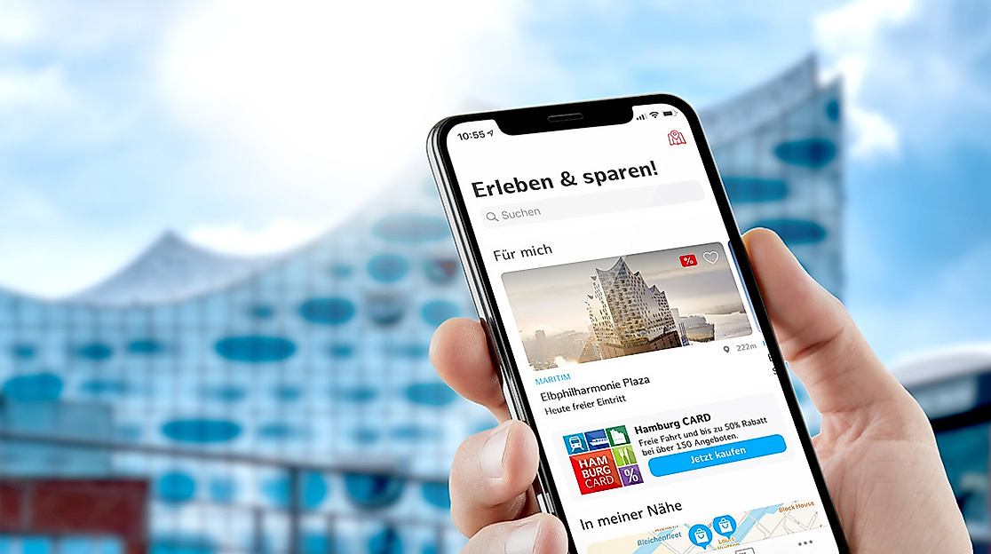 Smartphone in einer Hand vor Elbphilharmonie