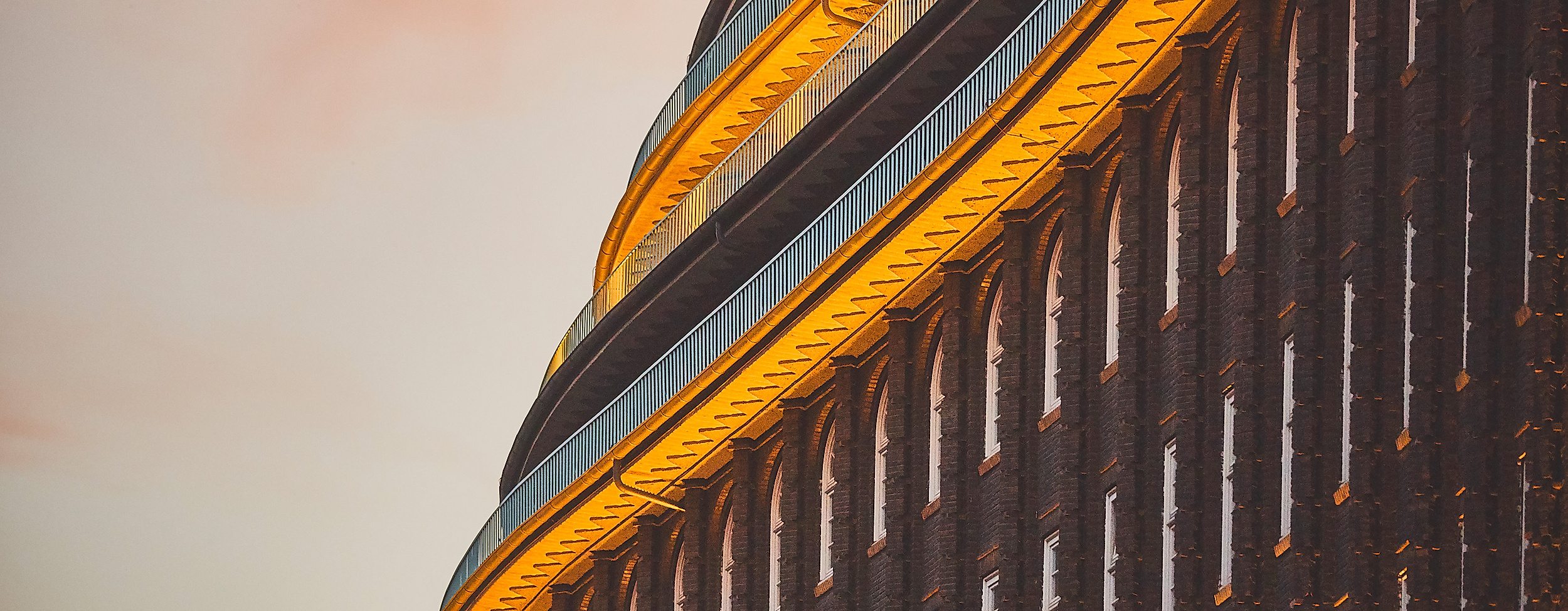 Beleuchtetes Rundelement der Fassade des Chilehauses in Hamburg bei Abenddämmerung