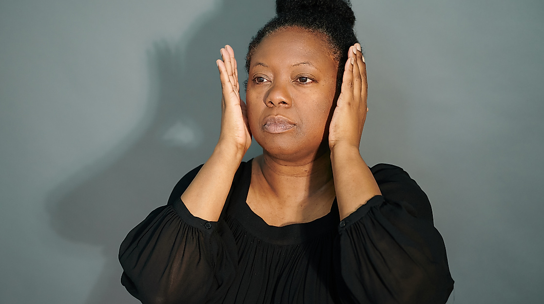 Nachdenkliche Pose vor grauem Hintergrund