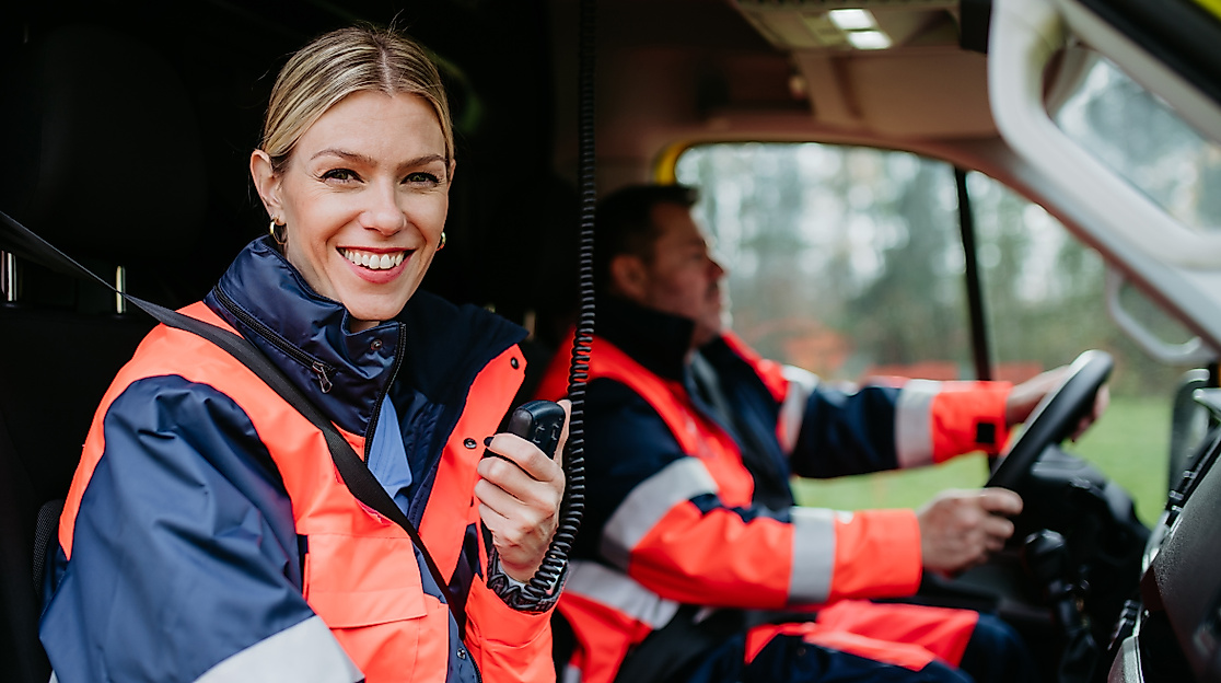 smiling-paramedic-woman-holding-radio-in-ambulance-2026-09-24-05-04-45-utc