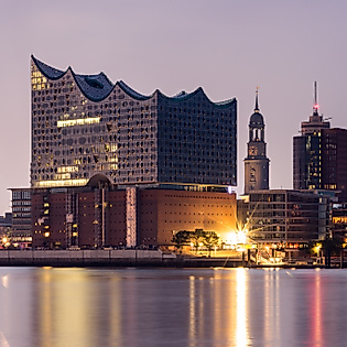 Elbphilharmonie und Michel bei Abenddämmerung von der gegenüberliegenden Seite der Elbe