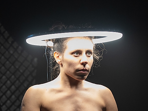 The head of a performer is surrounded by a bright circle of light.