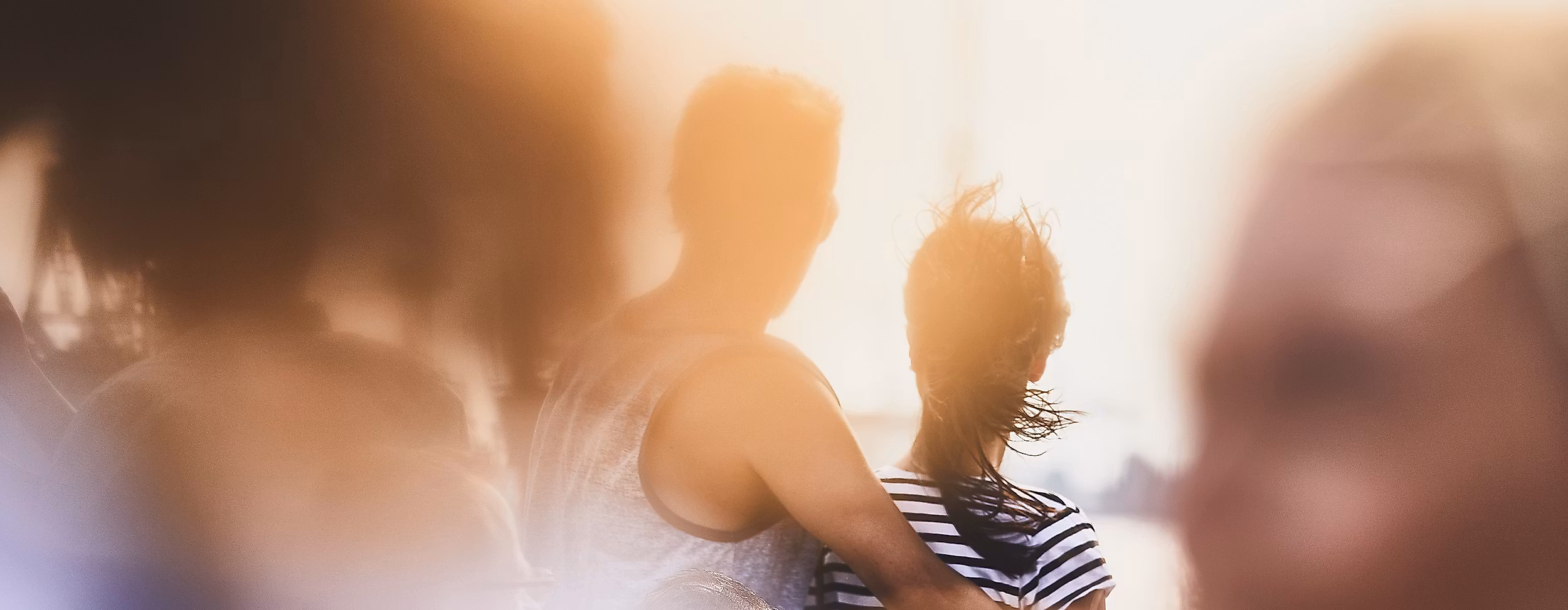 Zwei Personen im Gegenlicht am Hamburger Hafen, weich umrahmt von unscharfen Vordergründen