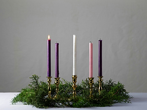 Adventskranz mit einer brennenden Kerze