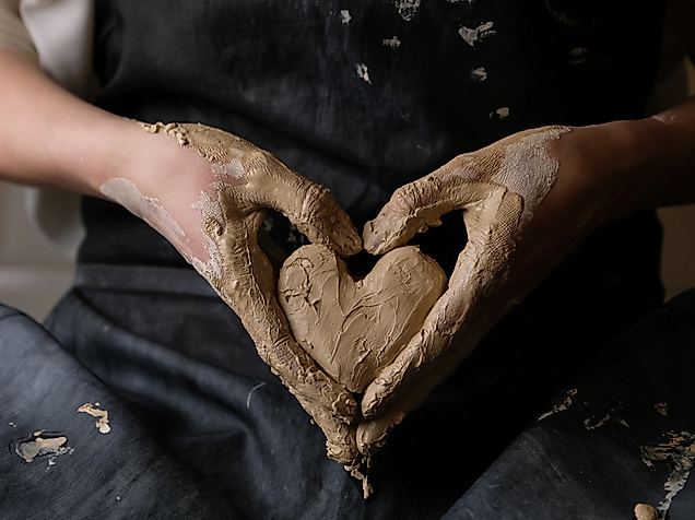 getoepfertes Herz in lehmverschmierten haenden