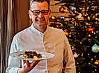 Spitzenkoch Thomas Martin serviert festliches Weihnachtsgericht vor Christbaum im Louis C. Jacob Hamburg
