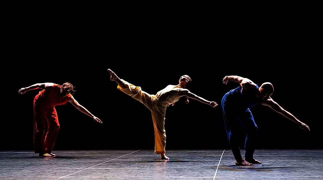 Performers Savannah Gaillard, Patrick Needham, Ashley Merker, Burr Johnson, Spencer Weidie, and Cecily Campbell dance virtuosically on stage, some jumping, others holding hands.