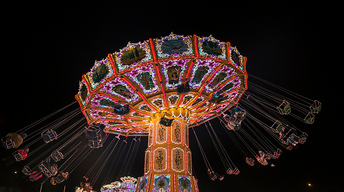 Beleuchtetes Kettenkarussell bei Nacht auf dem Winterdom in Hamburg als festliches Weihnachtserlebnis