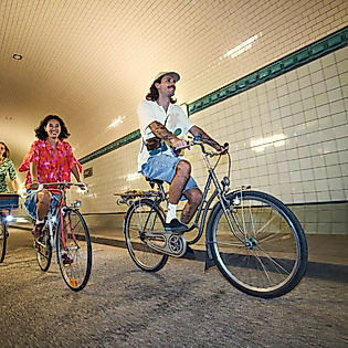 Drei junge Menschen fahren auf Fahrrädern durch den Elbtunnel.