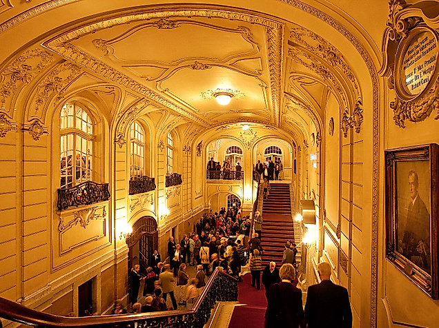Festlich beleuchtetes Treppenhaus der Laeiszhalle mit stuckverzierter Decke und Publikum in Abendgarderobe