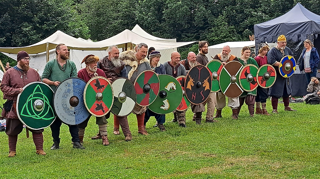 Aufreihung von mittelterlich gekleideten Männern mit Schildern