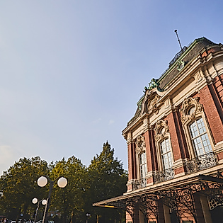Seitenansicht der Laeiszhalle Hamburg bei Sonnenschein mit Bäumen und blauem Himmel