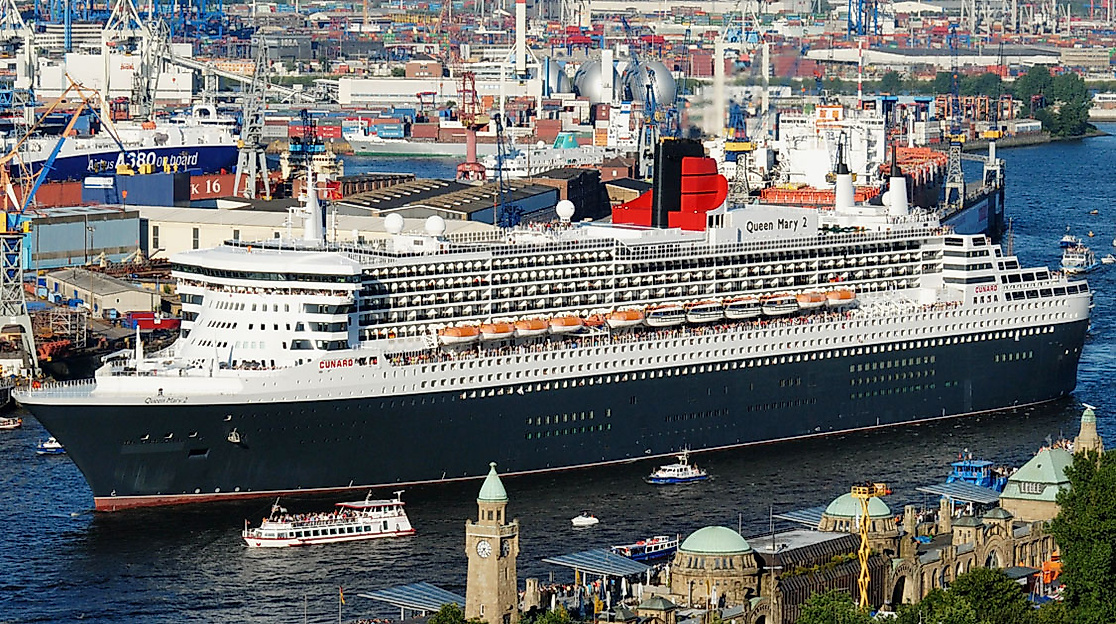 Queen Mary 2 fährt durch den Hamburger Hafen, im Vordergrund die Landungsbrücken, im Hintergrund Containerkräne