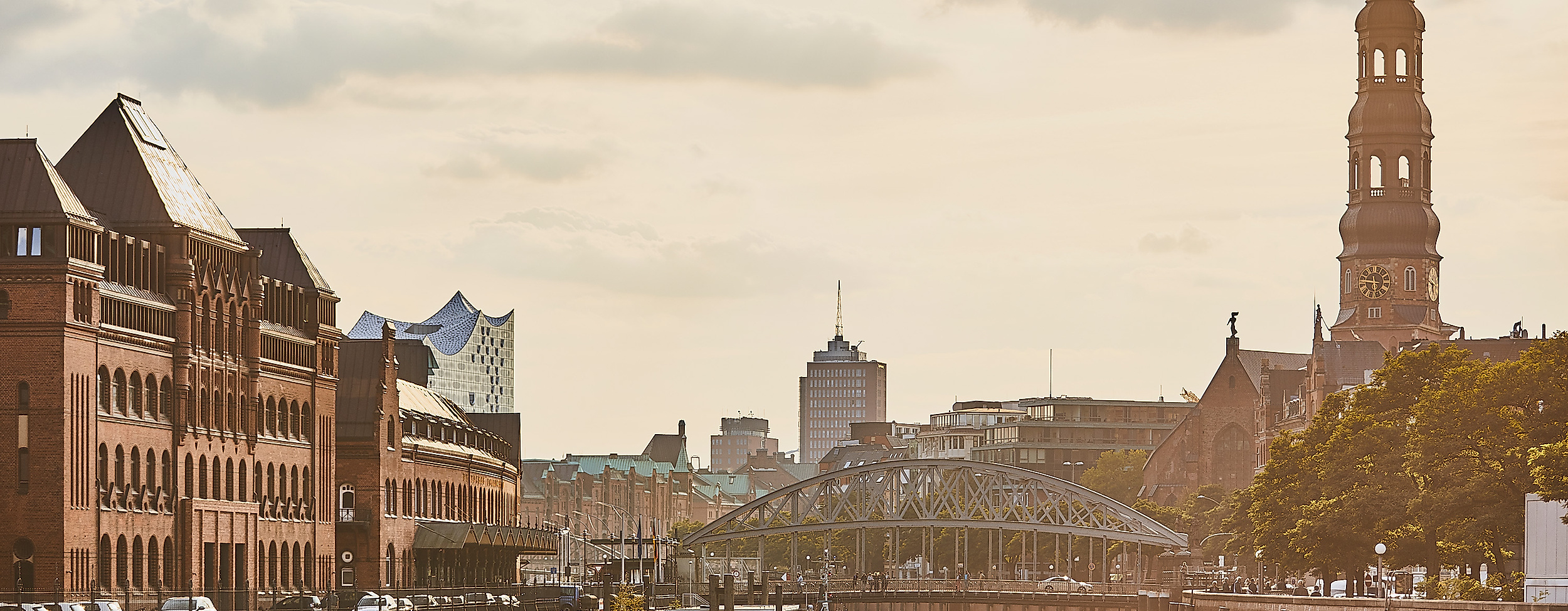 Abendstimmung in der Hamburger Speicherstadt mit Blick auf Kanal, historische Gebäude und Kirchturm