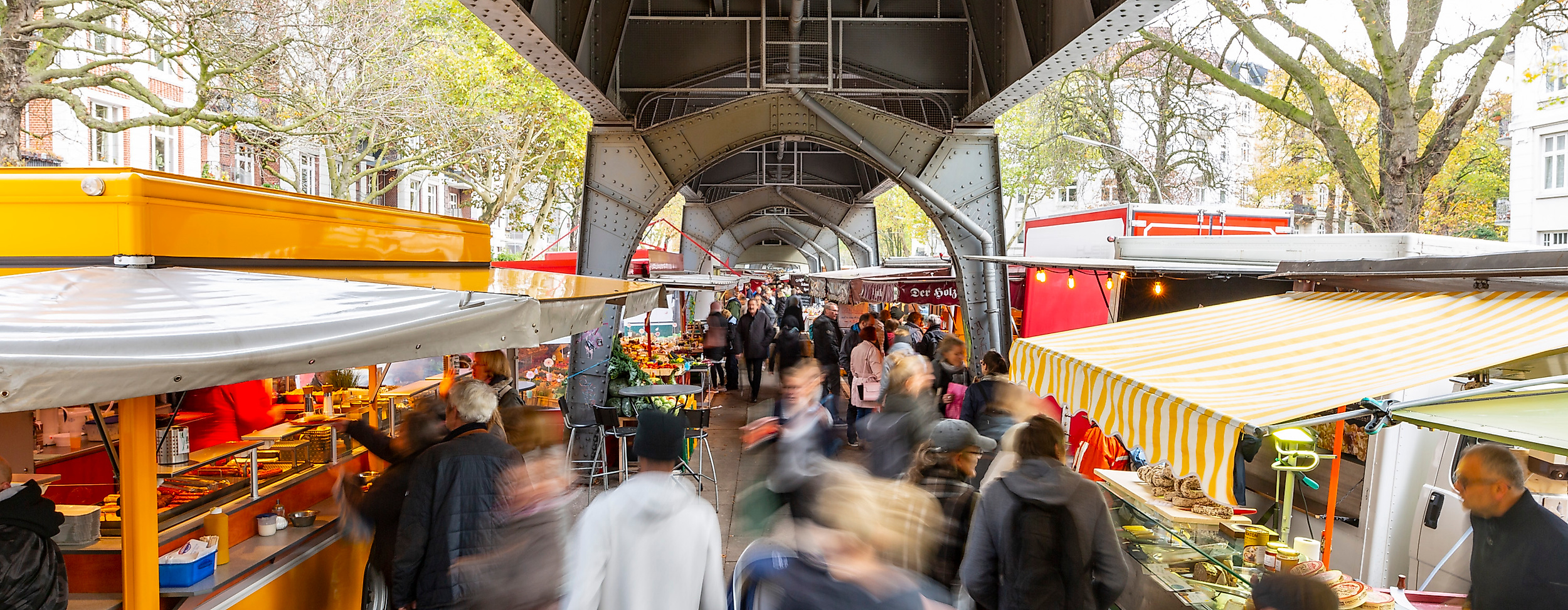 Isemarkt in Hamburg unter Hochbahn-Viadukt mit zahlreichen Marktständen und regem Besucherbetrieb