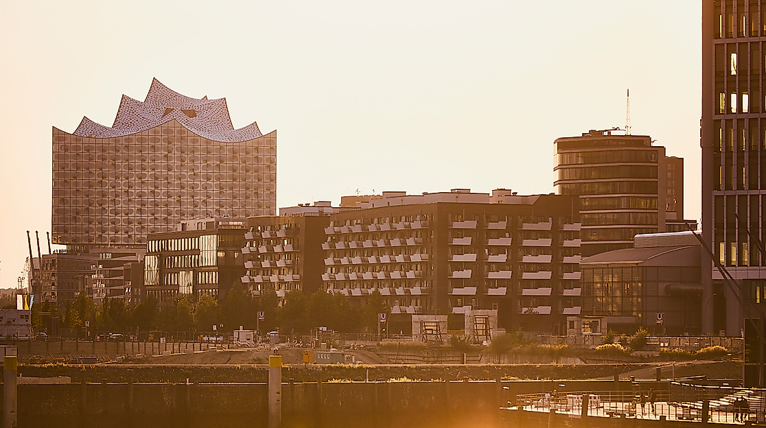 Elbphilharmonie von hinten, im Vordergrund moderne Hafencity-Architektur bei Sonnenuntergang