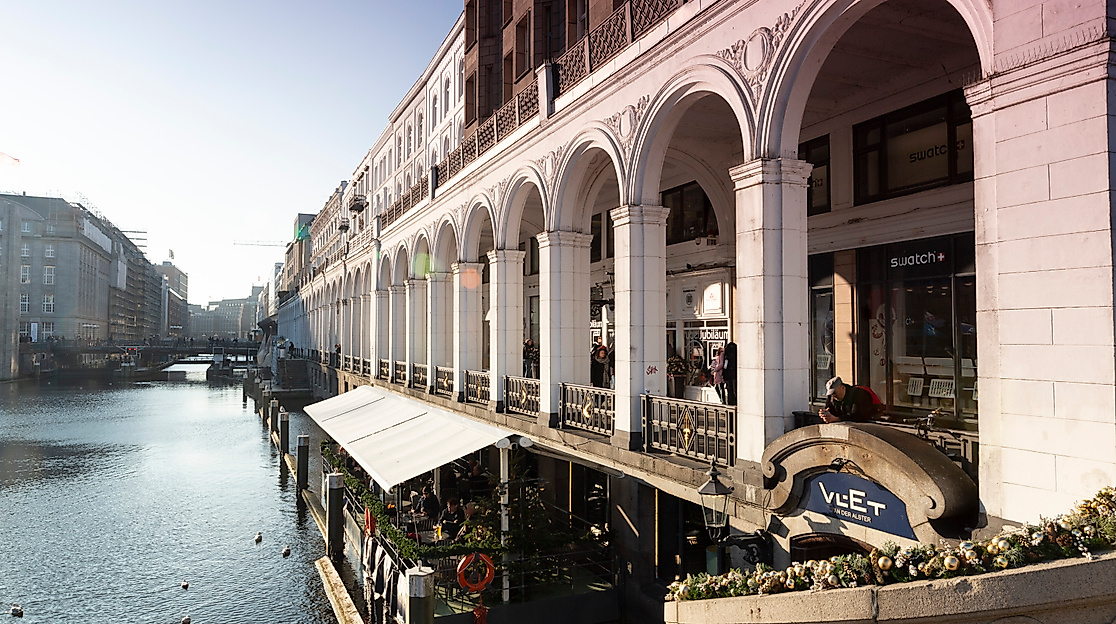 Alsterarkaden in Hamburg mit historischen Arkadenbögen und Außenterrassen direkt am Wasser