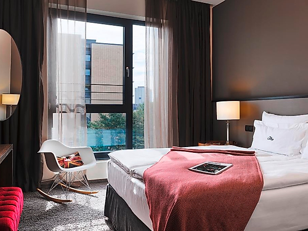 Modernes Zimmer mit Doppelbett, dunklen Wänden und großem Fenster 