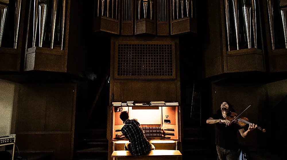 Stefan  Rusconi sitzt an der Orgel, neben ihm steht Tobias Preisig und spielt auf der Violine.