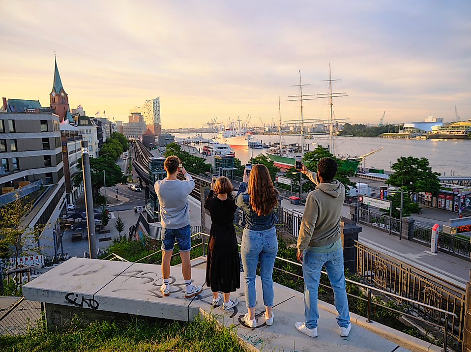 [Translate to English:] Touristen machen Fotos vom Hamburger Hafen und der Elbphilharmonie