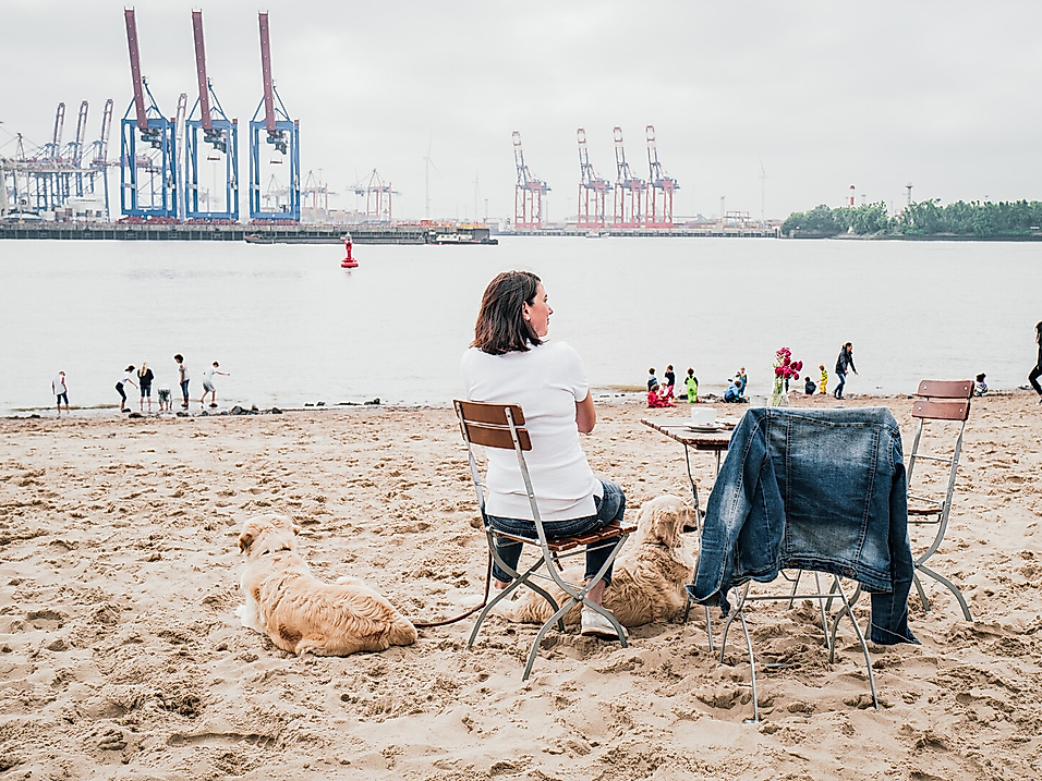Frau mit Hund am Elbstrand