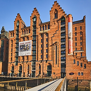 Backsteingebäude des Internationalen Maritimen Museums mit Banner und Brücke in der Hamburger Speicherstadt.