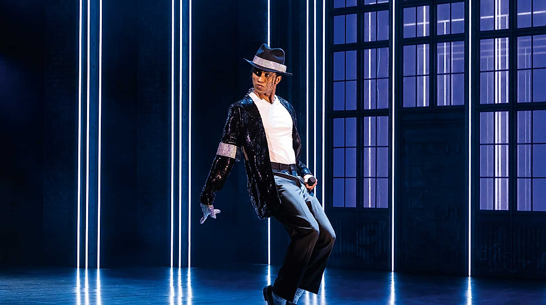 Tänzer in ikonischer Michael-Jackson-Pose auf Bühne mit Lichteffekten im Musical „MJ“ in Hamburg.