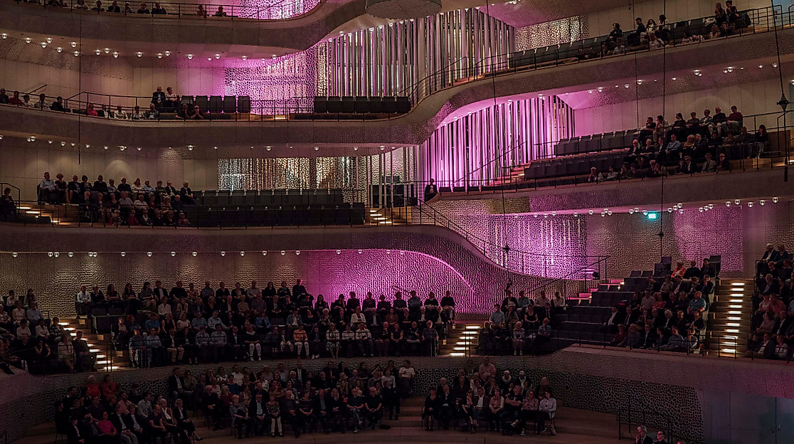 Beleuchteter Konzertsaal der Elbphilharmonie mit Orchester und Publikum beim InterMusikfest.