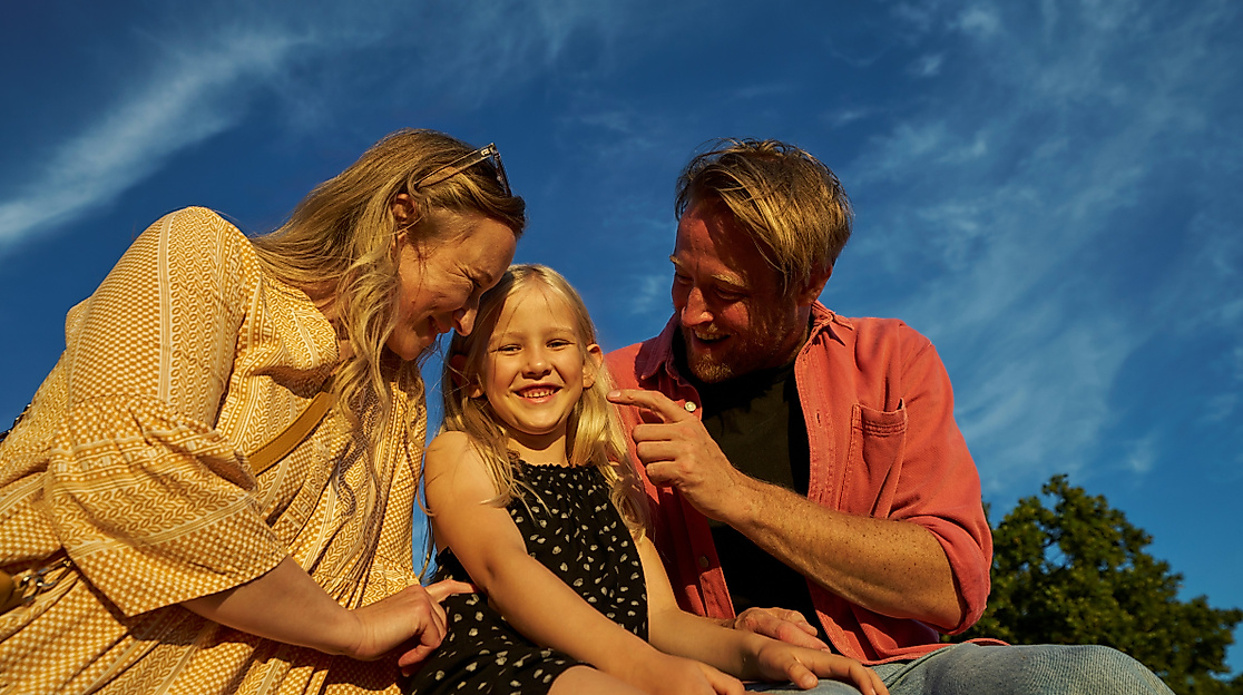 Eltern mit Kind vor Himmel