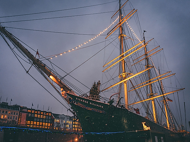 Historic sailing ship festively lit with Christmas lights at dusk in Hamburg’s harbor