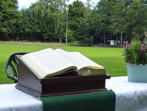 Aufgeschlagene Bibel und Blumenkorb auf einem Altar auf dem Fußballfeld