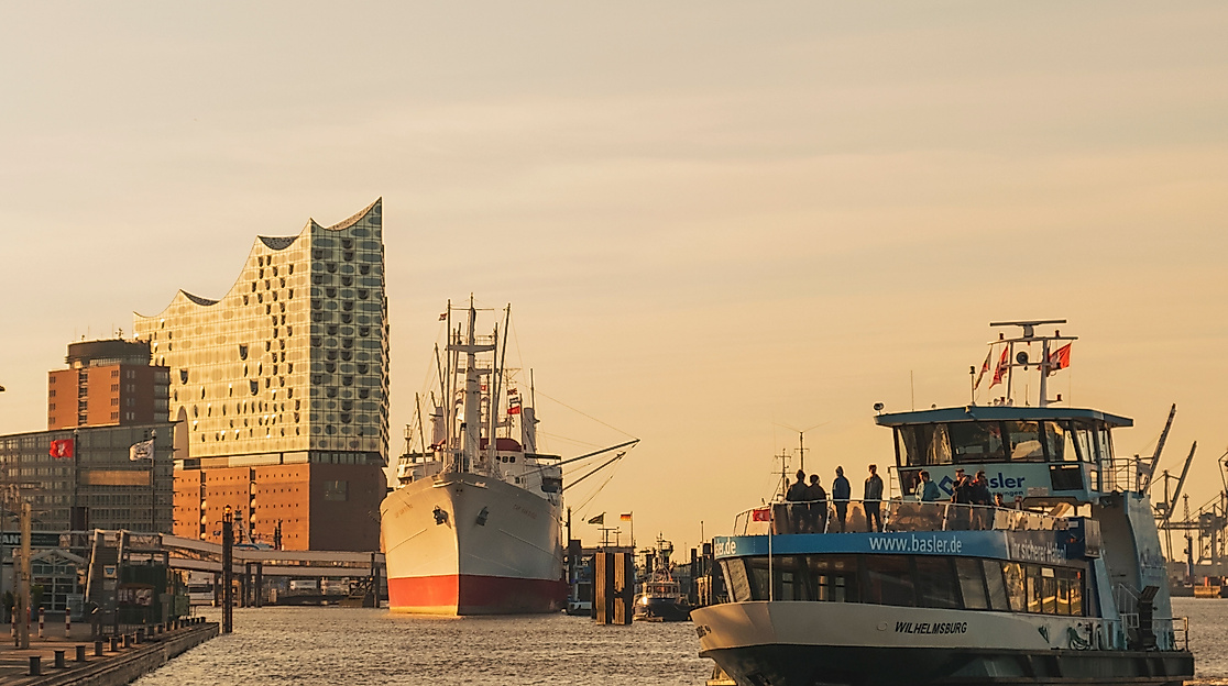 Fähre auf der Elbe vor Elbphilharmonie im goldenen Licht des Sonnenuntergangs im Hamburger Hafen