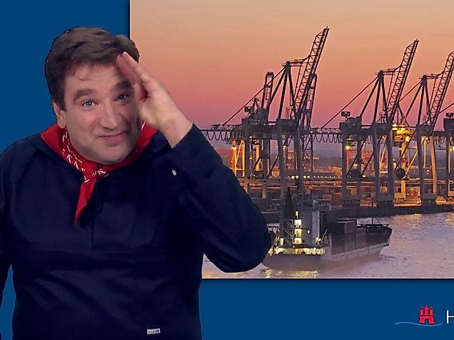 Man signing in International Sign in front of Hamburg Port at sunset – accessible tourism in sign language.