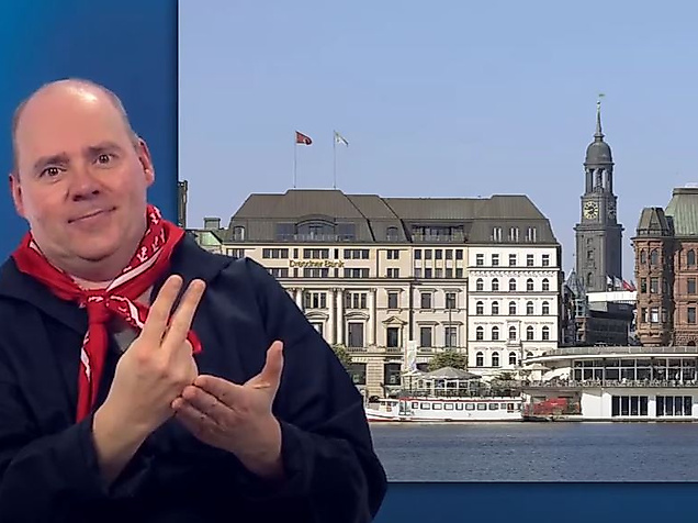 Mann gebärdet vor Panorama der Hamburger Innenstadt mit Alsterarkaden und Michel – barrierefreie Stadtinformationen.