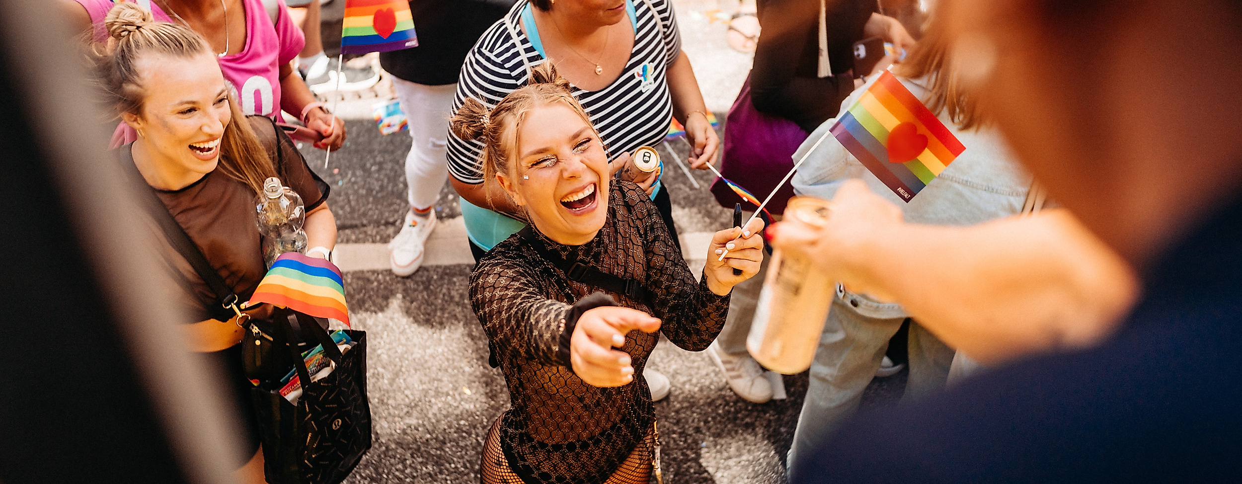 Fröhliche Menschen bei Hamburg Pride erhalten Getränke vom Wagen – queere Sichtbarkeit und Lebensfreude