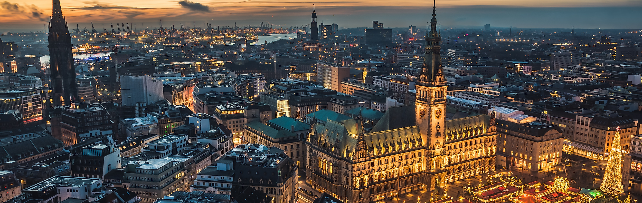 Blick über das abendliche Hamburg mit festlich beleuchtetem Weihnachtsmarkt rund um die Mönckebergstraße