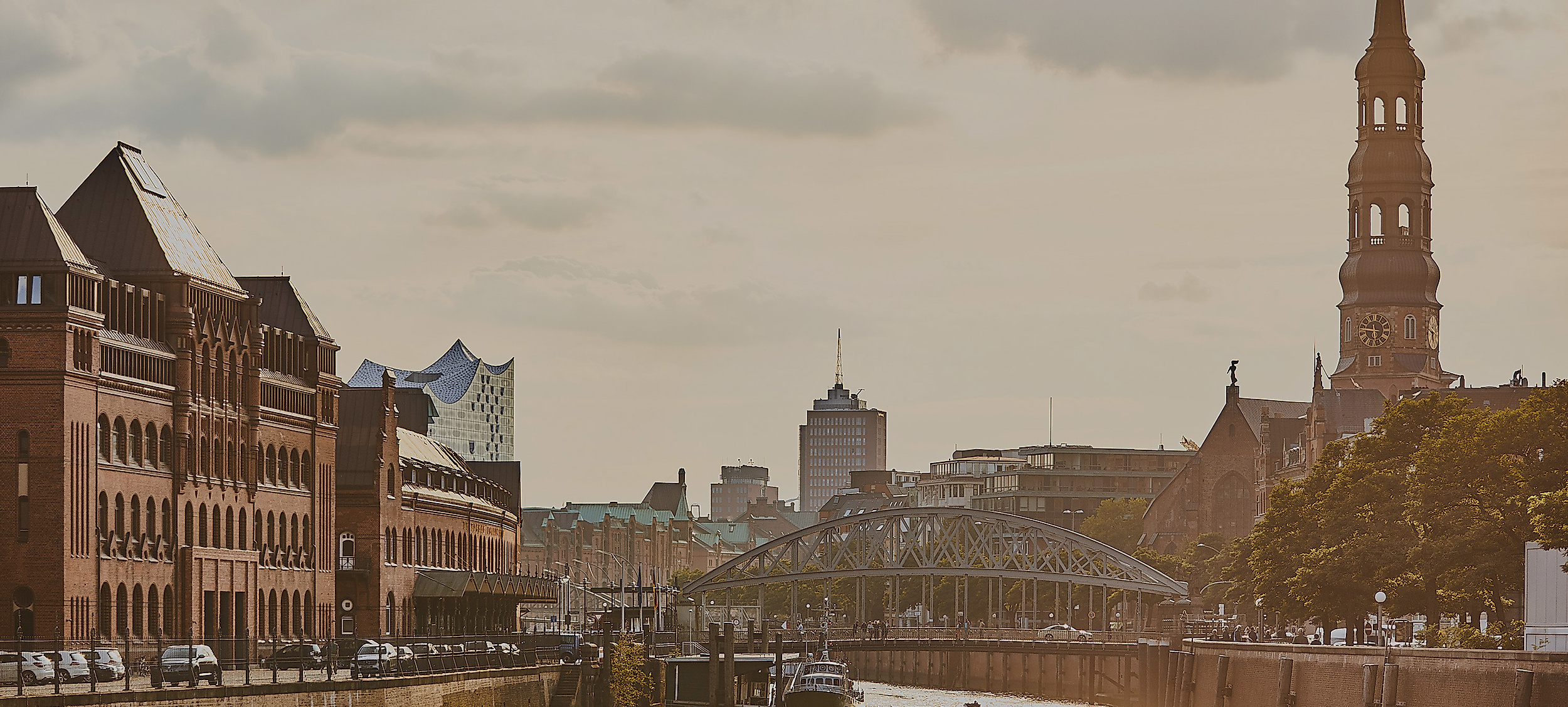 Blick auf Speicherstadt und Elbphilharmonie mit Nikolaikirche und Fleetszene im Hamburger Abendlicht