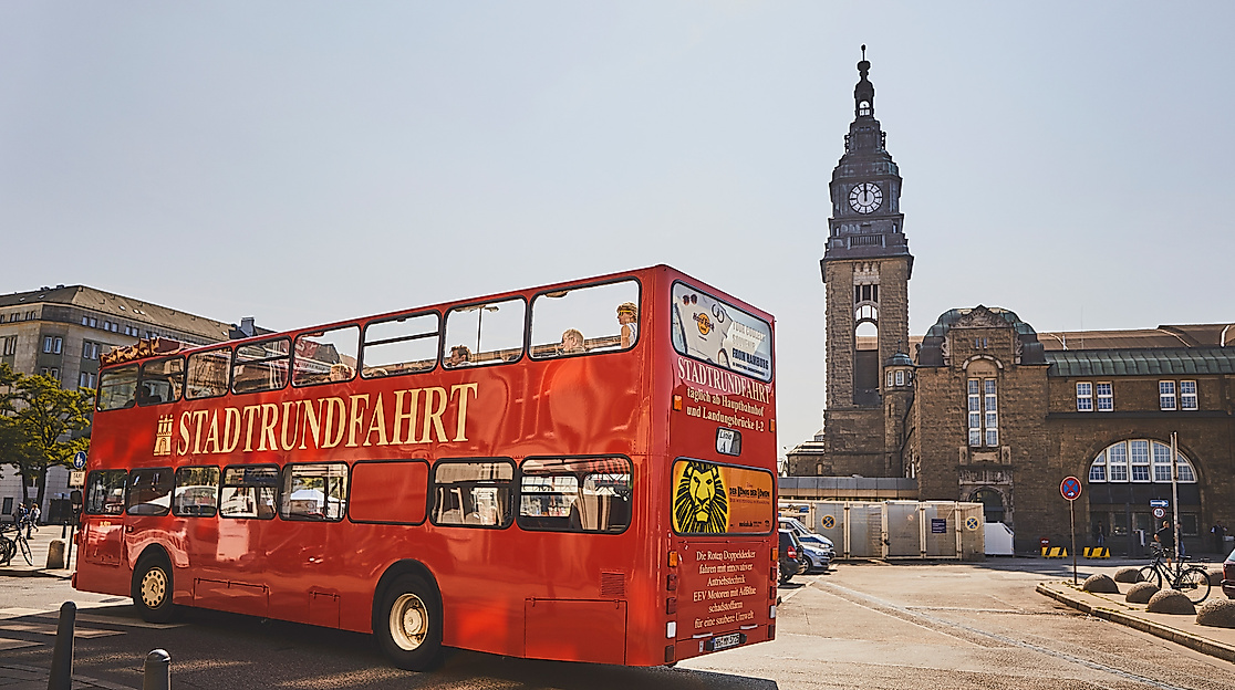 Roter Doppeldeckerbus vor dem Hamburger Michel bei sonniger Stadtrundfahrt
