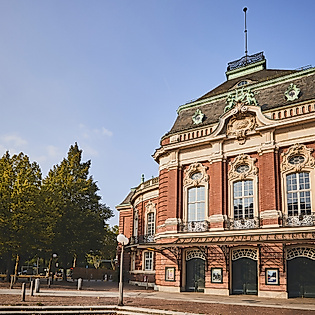 Außenansicht der Laeiszhalle Hamburg mit historischer Fassade und Bäumen bei sonnigem Wetter.
