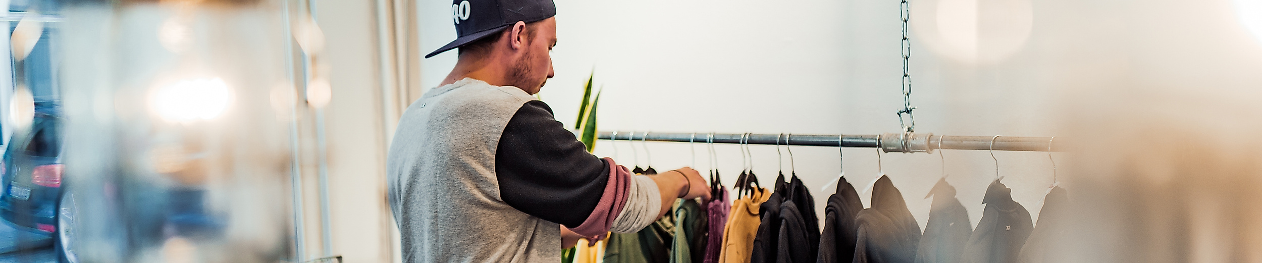 Kunde stöbert durch Streetwear an Kleiderstange im Mojo Store im Schanzenviertel Hamburg