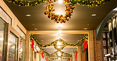 Festlich geschmückte Passage mit Lichterkränzen und Tannengirlanden in weihnachtlicher Abendstimmung