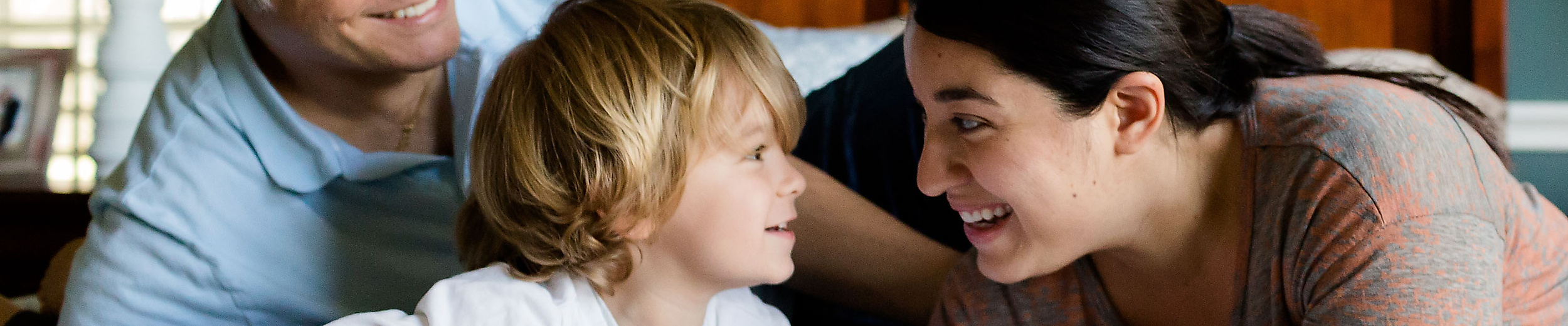 Mann, Frau und zwei Kinder zusammen auf einem Bett