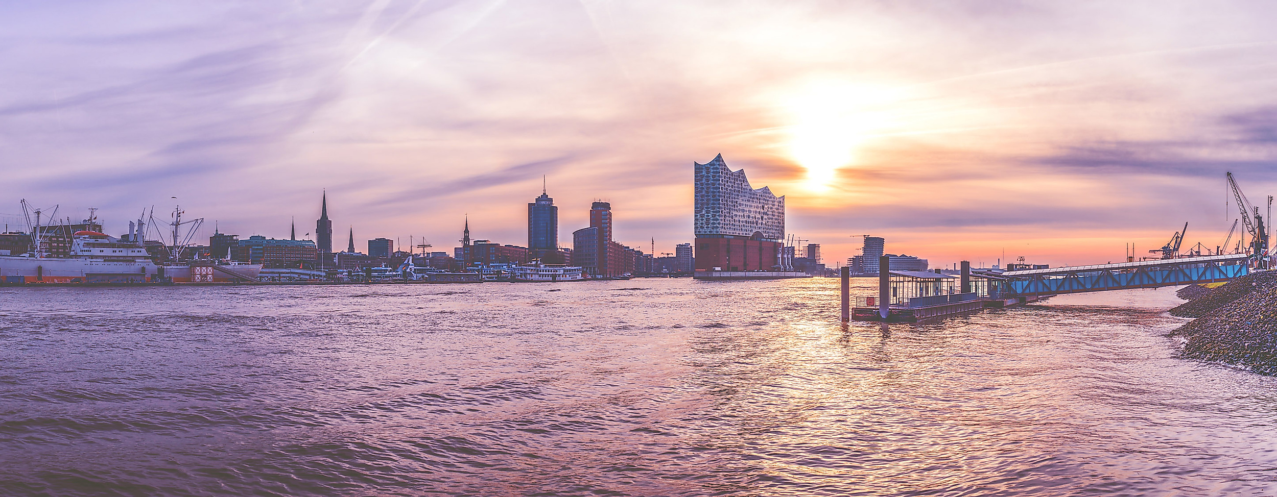 Panorama der Hamburger Skyline bei Sonnenuntergang mit Blick auf Hafen, Elbphilharmonie und Lichter am Elbufer