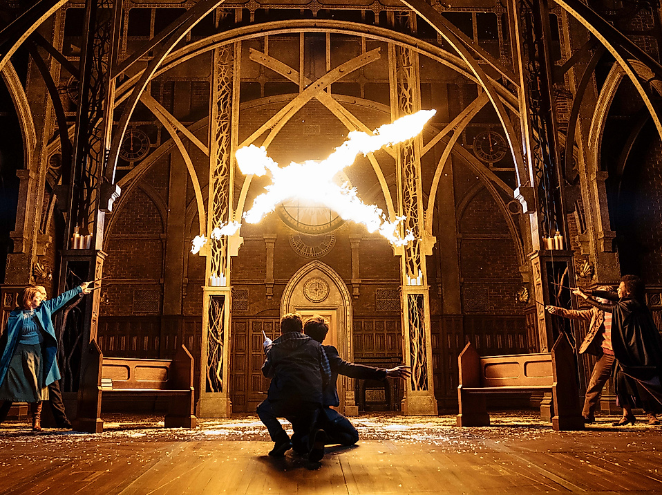 Szenenbild Harry Potter und das verwunschene Kind: Zauberei durch Flammen aus Zauberstäben in einer Halle