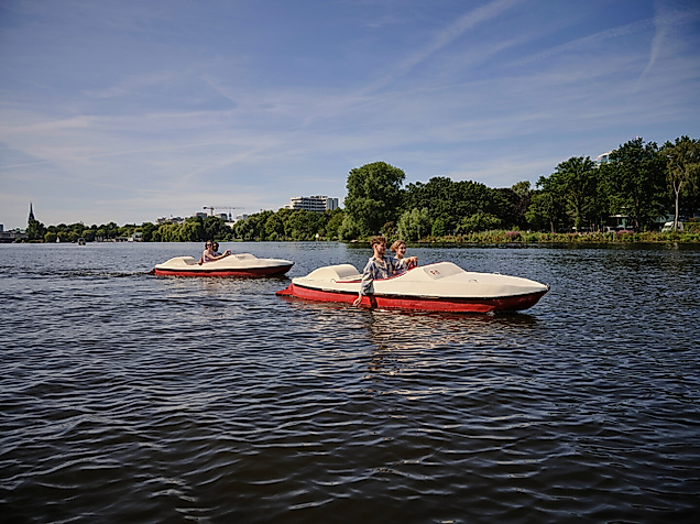 Zwei Tretboote mit Ausflüglern auf der Alster an einem sonnigen Sommertag in Hamburg