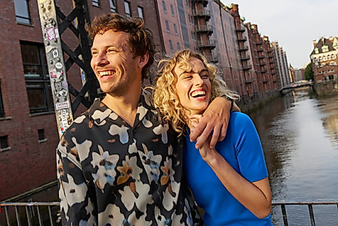 Paar lacht in die Kamera im Hintergrund sieht man das Wasserschloss