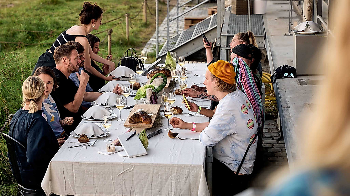Leute sitzen am Tisch und genießen das OPEN MOUTH Hamburg Food Festival